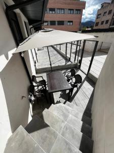 een tafel en stoelen op een balkon met een parasol bij VUT Mar de Llanes in Llanes