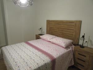 een slaapkamer met een bed met een houten hoofdeinde bij VUT Mar de Llanes in Llanes