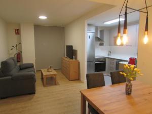 een woonkamer met een bank en een tafel en een keuken bij VUT Mar de Llanes in Llanes