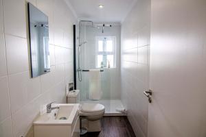 uma casa de banho com um WC, um lavatório e um chuveiro em Pine House - Faro Airport, Beach and City Center em Faro