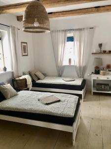 1 Schlafzimmer mit 3 Betten und einem großen Fenster in der Unterkunft Dom z Bieszczad na Kaszubach - całoroczny dom z balią ogrodową in Kowalewo