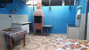 a brick oven in a room with a blue wall at CASA TEMPORADA PERUIBE in Peruíbe