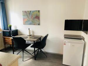 a room with a table and chairs and a television at Hills Hut in Langelsheim