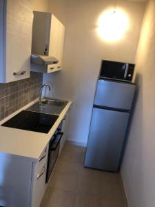 a small kitchen with a refrigerator and a sink at Green Apartment in La Maddalena