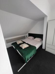 a bedroom with two beds with green sheets at Charmed HomeStay - Zaczarowany in Warsaw