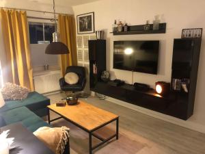 een woonkamer met een bank, een tafel en een tv bij Eresburg Apartment. in Marsberg