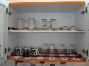 una fila de frascos de vidrio en un estante de una cocina en Charm Ville - Villa with Nature in Hosur en Hosūr
