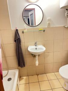 ein Bad mit einem Waschbecken und einem Spiegel in der Unterkunft Ubytování Sýkora Apartments in Veľký Meder