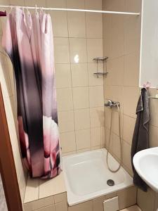 bagno con doccia con tenda rosa di Ubytování Sýkora Apartments a Veľký Meder