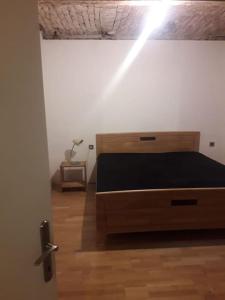 um quarto com uma cama e piso em madeira em Old Central 2-room souterrain flat em Brno