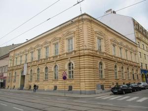um grande edifício de madeira ao lado de uma rua em Old Central 2-room souterrain flat em Brno