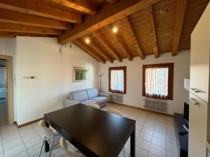 a living room with a table and a couch at Cà Maria - Appartamento Mansardato al primo piano in San Polo di Piave