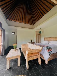 a bedroom with a bed and two tables in it at Widya Luxury House in Ubud