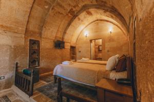 a bedroom with a bed in a stone room at Zula Cave House in Urgup