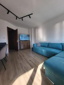 un salon avec un canapé bleu et une télévision à écran plat dans l'établissement KS Rooftop 180°, à Bansko