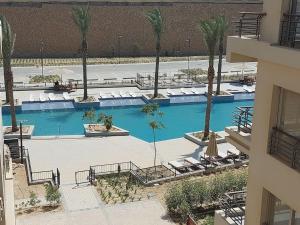 an overhead view of a large swimming pool with palm trees at Alumia Marigold Suite 3BR Apt Pool Access in Cairo
