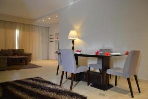Rivoli Suites and Spa في الغردقة: غرفة معيشة مع مكتب مع كراسي وأريكة