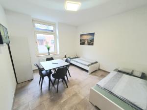 een kamer met een bed en een tafel en stoelen bij Stadtmensch Oberhausen 3 Schlafzimmer in Oberhausen