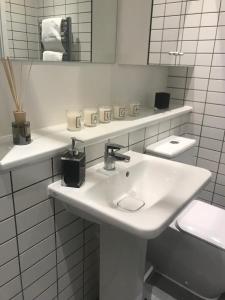 Baño blanco con lavabo y espejo en Central Charm Dwelling, en Londres