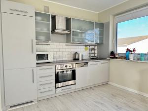 uma cozinha com electrodomésticos brancos e uma grande janela em Nadmorski Chill - Comfy Apartments em Gdansk