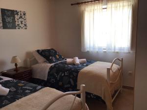 a bedroom with two beds and a window at Monte da Palmeirinha in Vila Nova de Milfontes +14 photos