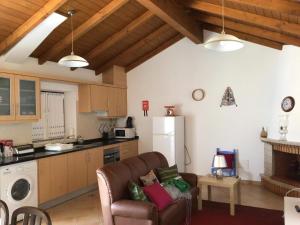 a living room with a couch and a kitchen at Monte da Palmeirinha in Vila Nova de Milfontes