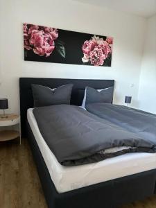 1 dormitorio con 1 cama con flores rosas en la pared en Ferienhaus H-Auszeit en Fichtelberg