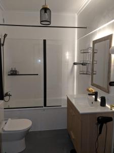 uma casa de banho com um chuveiro, um WC e um lavatório. em Rooms 10 mins walk from train station! em Agualva