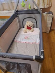 a teddy bear sitting in a baby crib at Lena apartment - Lena two bedroom apartment in Vecsés