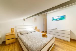 a bedroom with a large white bed and wooden floors at T3 Résidence de tourisme Voltaire in Hyères