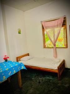 ein kleines Schlafzimmer mit einem Bett und einem Fenster in der Unterkunft Obeisance in Tangalle