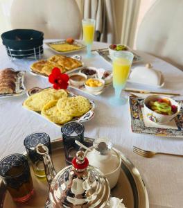 - une table avec un plateau de produits pour le petit-déjeuner et des boissons dans l'établissement Villa Sofia - Golf Amelkis Marrakech, à Marrakech