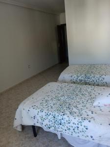 1 dormitorio con 2 camas con sábanas azules y blancas en EL ABAD en Abadía