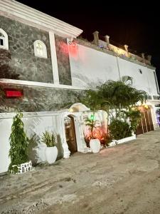 una casa con plantas delante de ella por la noche en Résidence ARCHANGE en Pointe-Noire