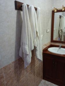 baño con toallas blancas colgadas en la pared en EL ABAD en Abadía