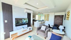 sala de estar con TV, sofá y mesa en Suite con Vista al Mar, Piscinas, Jacuzzi, Wifi, en Playas