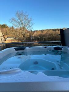 a jacuzzi tub with a view of the countryside at Ferienhaus H-Auszeit in Fichtelberg