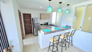 a kitchen with a bar with stools and a counter top at Suite con Vista al Mar, Piscinas, Jacuzzi, Wifi in Playas