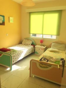 1 Schlafzimmer mit 2 Einzelbetten und einem Fenster in der Unterkunft Beautiful Apartment near the Sea in Paphos City