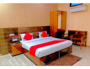 a bedroom with a large bed with red pillows at Hotel Highway, Udhampur in Udhampur