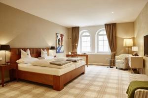 ein Hotelzimmer mit einem Bett, einem Schreibtisch und einem Schlafzimmer in der Unterkunft Hotel Gutsgasthof Stangl in Neufarn