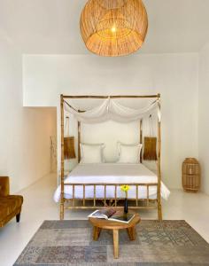 a bedroom with a canopy bed and a coffee table at Mansa Marina Hotel in Mindelo