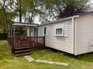 a white house with a porch and a deck at GHVacances PiPiou Lac de Parentis en Born in Parentis-en-Born