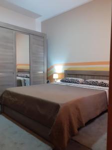 Un dormitorio con una cama grande con un espejo grande. en Cosy Home by the Sea, en Birżebbuġa