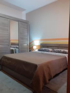 a bedroom with a large bed with a large mirror at Cosy Home by the Sea in Birżebbuġa