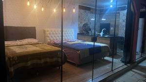 Zimmer mit 2 Betten, einem Waschbecken und einem Spiegel in der Unterkunft Quarto amplo com tv geladeira e fogão in Rio Negro