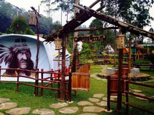 a playground with a large painting of a man at Wong Deso Camping in Seminyak