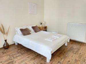un letto bianco in una camera da letto con pavimento in legno di Unique Apartments in Döbling a Vienna