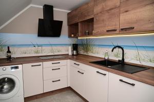a kitchen with a sink and a washing machine at Ferienwohnung am Kalten Bach in Dürrröhrsdorf