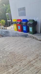a group of four trash cans sitting next to a building at Joy Camping & Rooms in Haad Rin